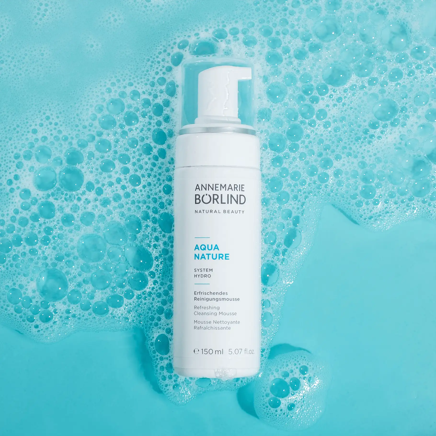ANNEMARIE BÖRLIND AQUA NATURE erfrischendes Reinigungsmousse vor blauem, schaumigem Wasserhintergrund