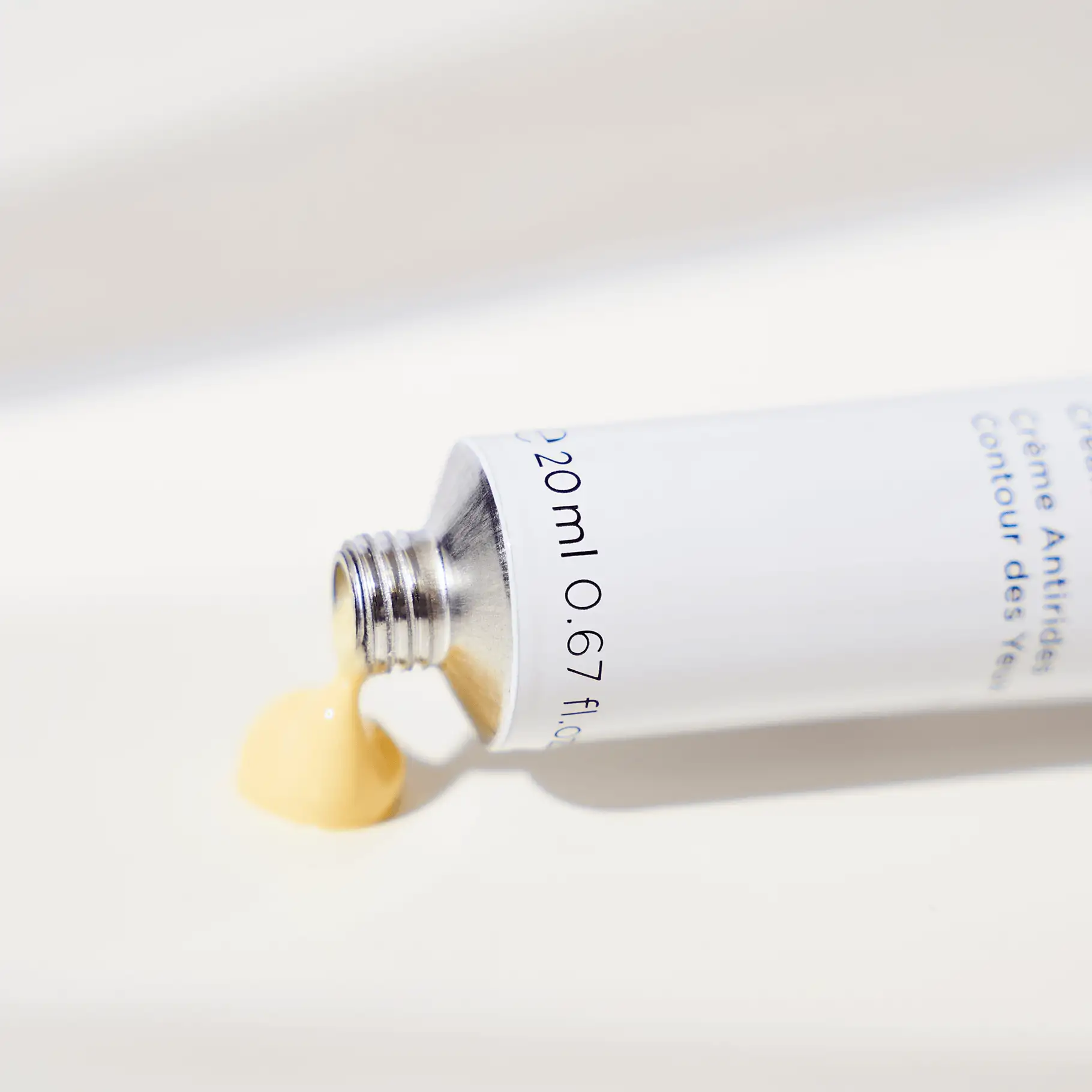 ANNEMARIE BÖRLIND Augen-Fältchen-Creme in Tube mit gelblicher, cremiger Textur auf weißem Untergrund