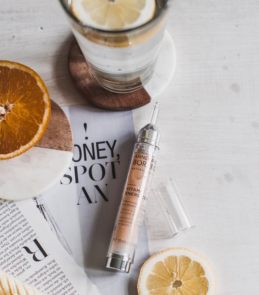 ANNEMARIE BÖRLIND Vitamin Energizer Ampulle auf weißem Tisch mit Zitronen- und Orangenscheiben
