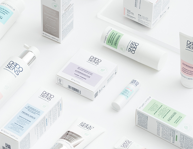 DADO SENS Hautpflegeprodukte mit Gesichtscremes, Lippenpflege und Intensivcreme in weiß-grüner Verpackung auf weißem Hinte...