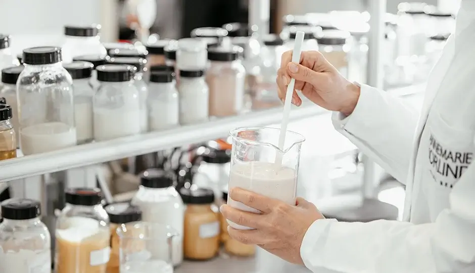 Mensch in einem Labor mit vielen befüllten Gläsern