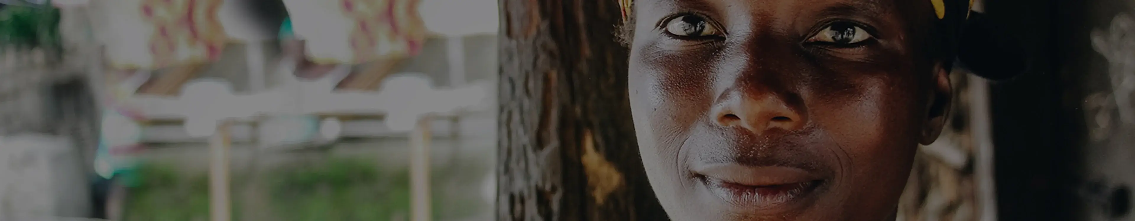 Nahaufnahme eines nachdenklichen Mannes vor einem Baum mit unscharfem, ländlichem Hintergrund