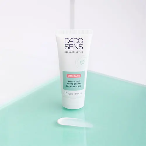 DADO SENS SOS CARE Akutcreme 30 ml mit Cremeprobe auf mintgrünem Untergrund