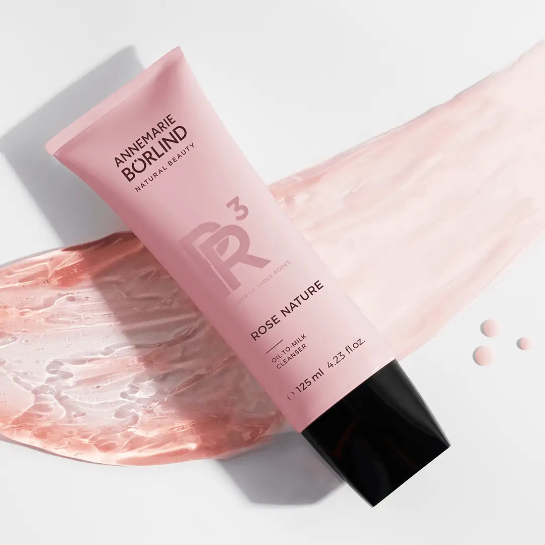 ANNEMARIE BÖRLIND ROSE NATURE Oil-to-Milk Cleanser 125 ml Tube auf rosafarbenem Produktmuster