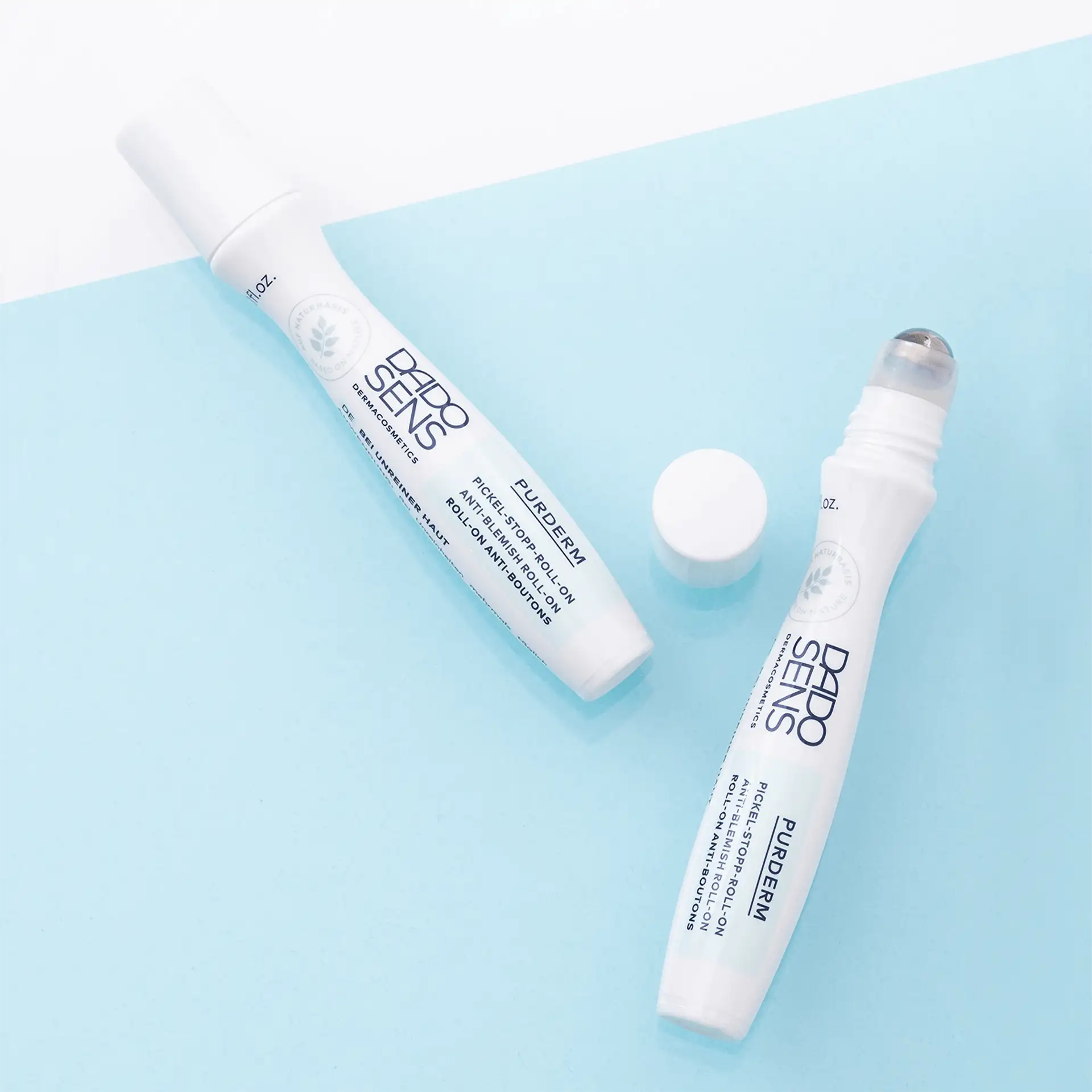 DADO SENS PURDERM Pickel-Stopp-Roll-on mit Rollerkugel und weißem Schraubverschluss auf blauem Hintergrund