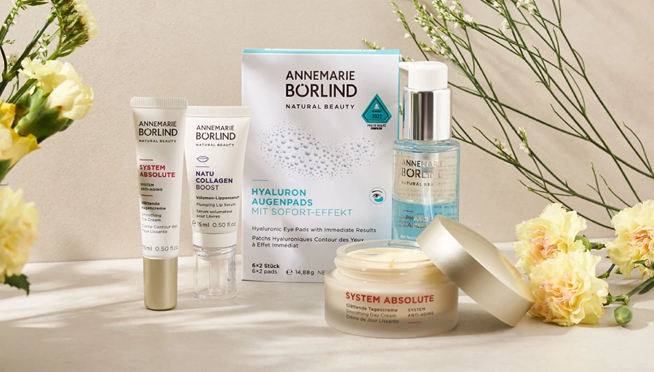 Nachhaltige Kosmetik Pflegeprodukte von ANNEMARIE BÖRLIND – Augenpflege, Creme, Augenpads und Serum – auf neutralem Untergrund mit Blumen und Blattschatten im Hintergrund.