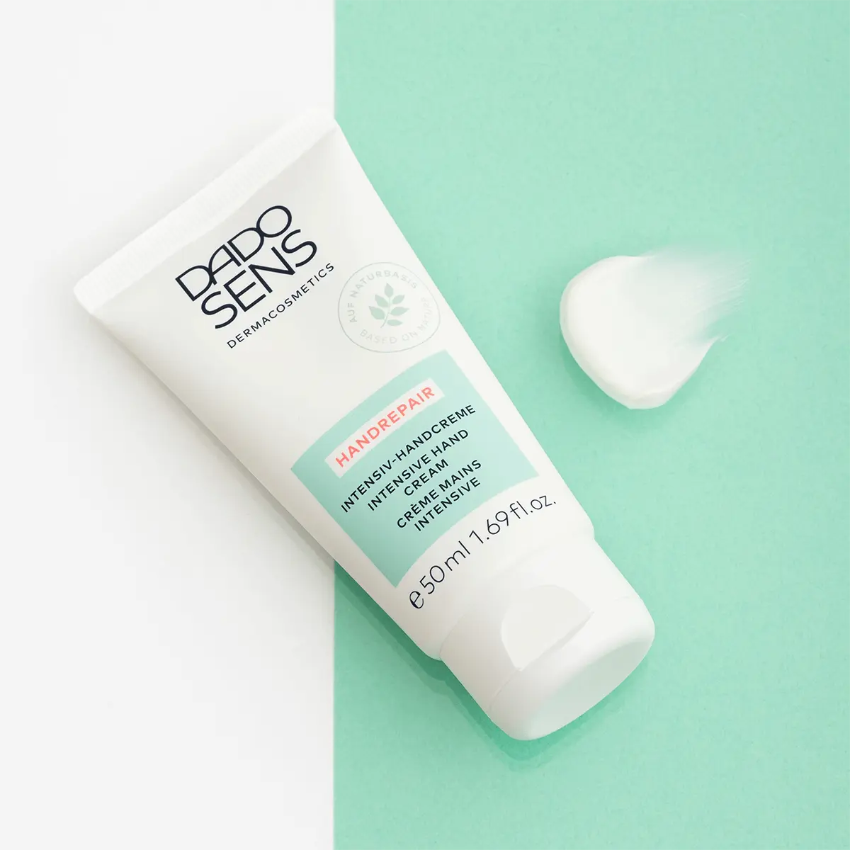 DADO SENS Intensiv-Handcreme 50 ml Tube mit Creme-Textur auf grün-weißem Hintergrund