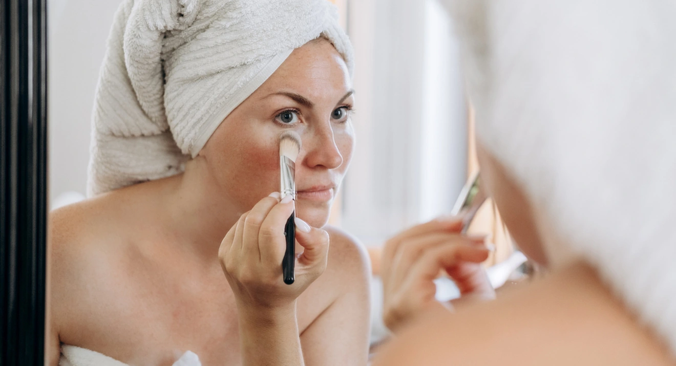 Augenringe abdecken mit Make-up: Tipps für einen frischen Look Frau trägt Make-up mit Pinsel unter den Augen auf – einfache Methode, um Augenringe abdecken zu können