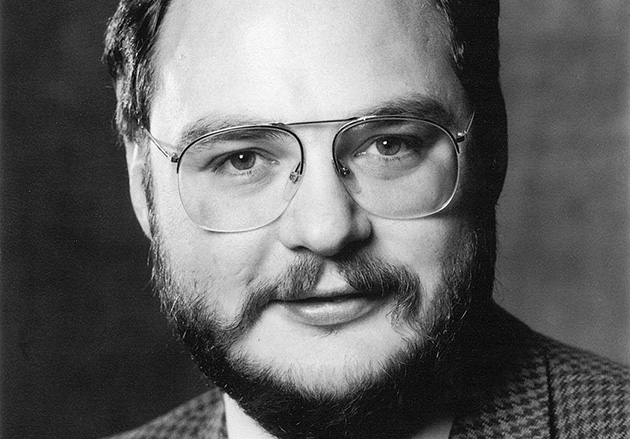 Porträt eines Mannes mit Brille und Bart, schwarz-weiß, vor neutralem Hintergrund