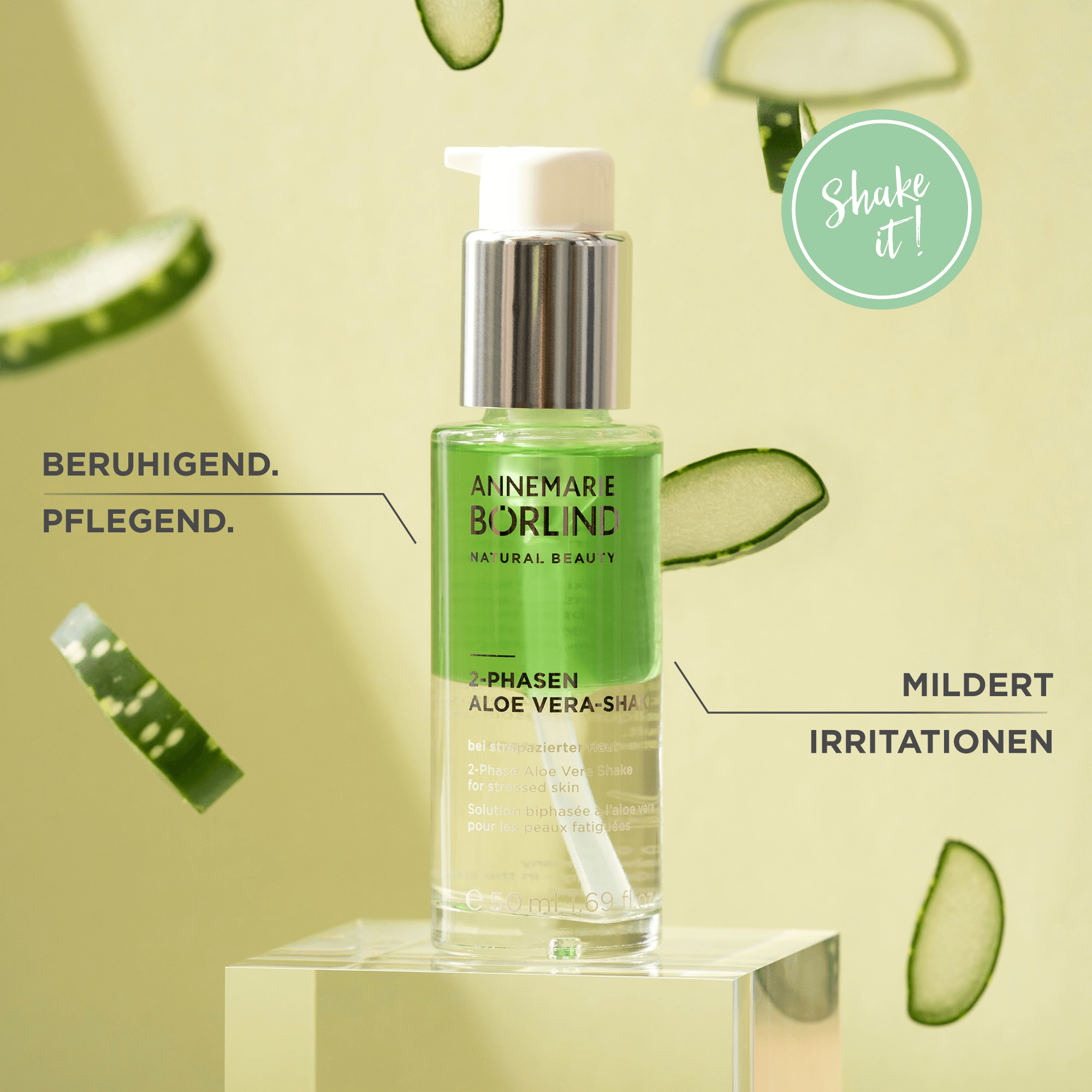 ANNEMARIE BÖRLIND 2-Phasen Aloe Vera Shake auf transparentem Podest mit Gurkenscheiben im Hintergrund