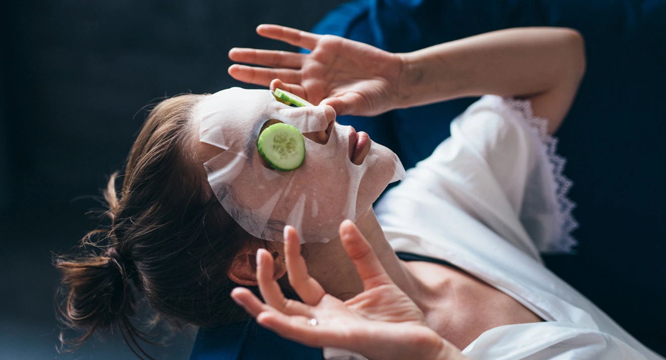 Augenringe abdecken und pflegen: Hausmittel & Tipps Frau mit Gesichtsmaske und Gurkenscheiben auf den Augen – natürliche Pflege, um Augenringe abdecken und mildern zu können