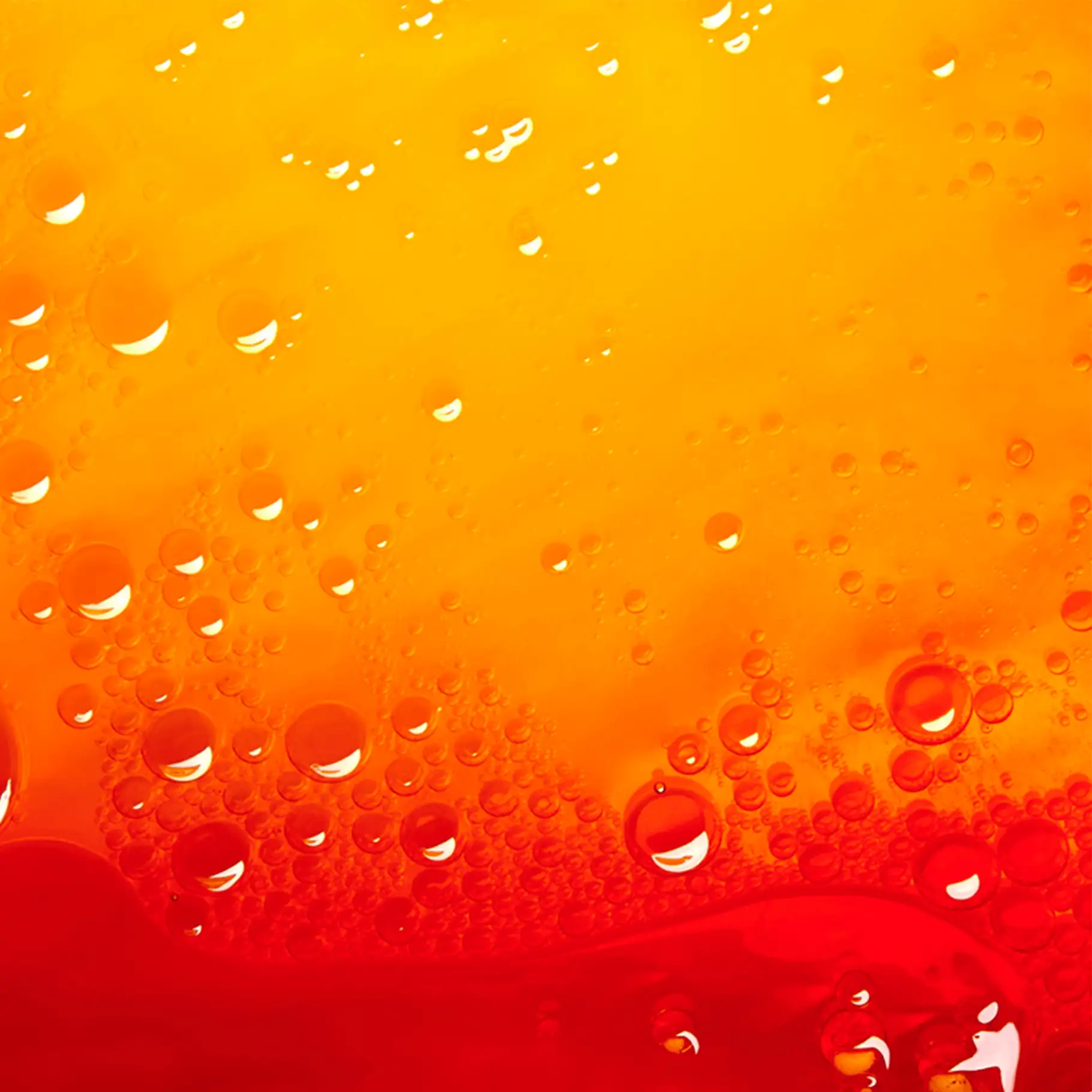 Nahaufnahme von zwei Phasen mit gelbem und rotem Öl, die sich nicht vermischen, mit vielen Luftblasen