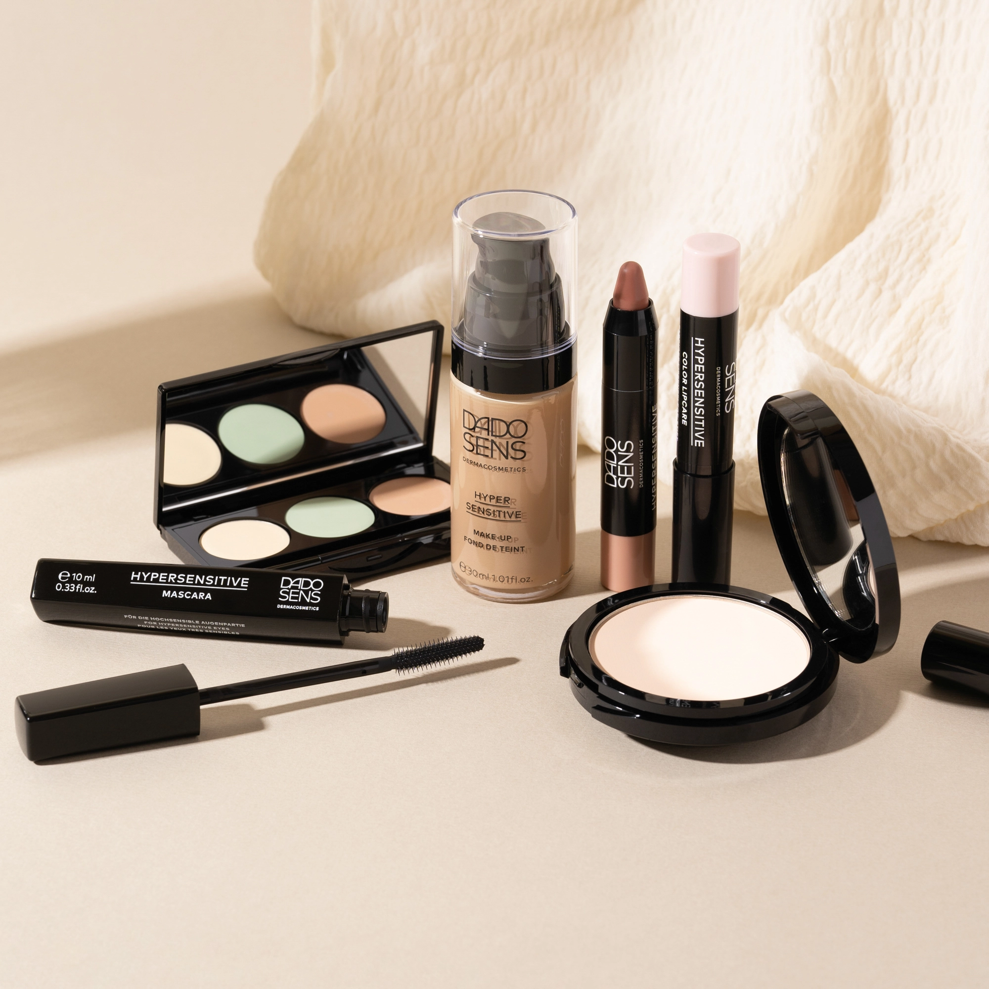 DADO SENS HYPERSENSITIVE Make-up mit Foundation, Mascara, Concealer, Lippenstift und Puder auf hellem Hintergrund