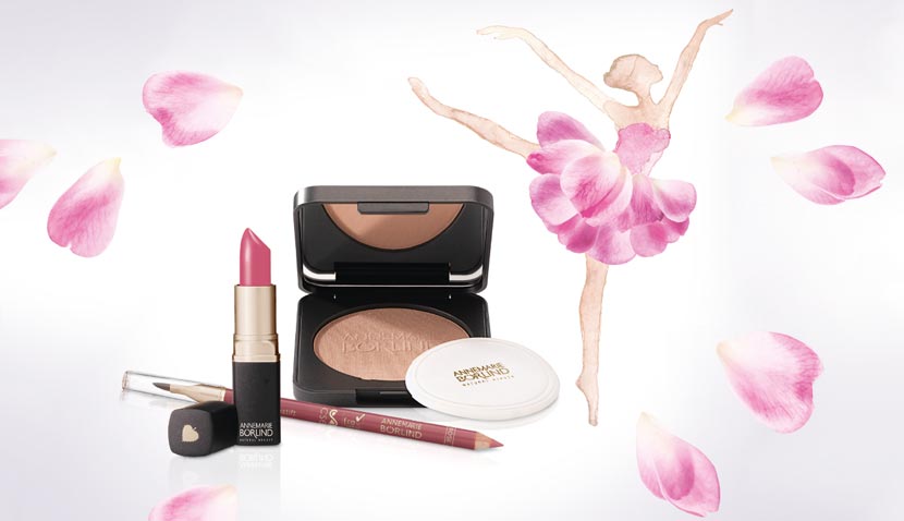 ANNEMARIE BÖRLIND Lippenstift, Puder, Lipliner vor Ballerina aus Rosenblättern und verstreuten Blütenblättern