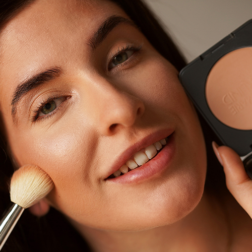 Frau trägt hellbraunen ANNEMARIE BÖRLIND Bronzer mit Pinsel auf Wange auf, Nahaufnahme Gesicht