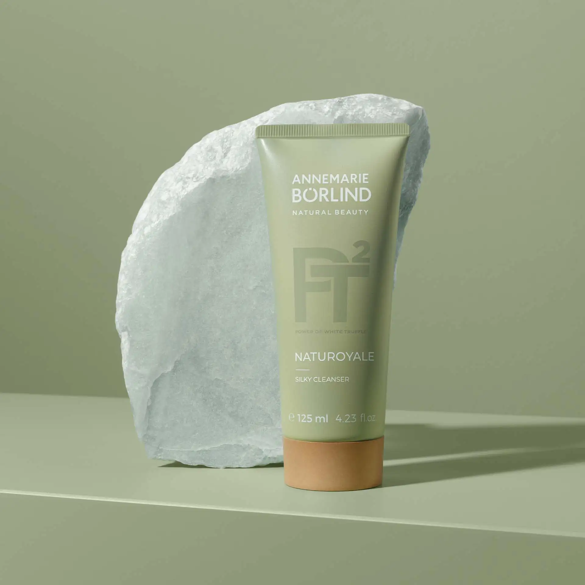 ANNEMARIE BÖRLIND NATUROYALE Silky Cleanser 125 ml vor hellem Stein auf grünem Hintergrund