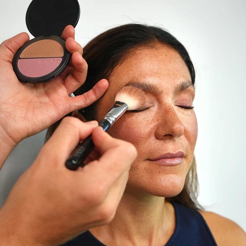 Make-up Artist Kevin Bete trägt mit einem Pinsel den 2in1 Bronzer & Blush als Lidschatten für den Herbstlook „A Hug of Colour“ auf