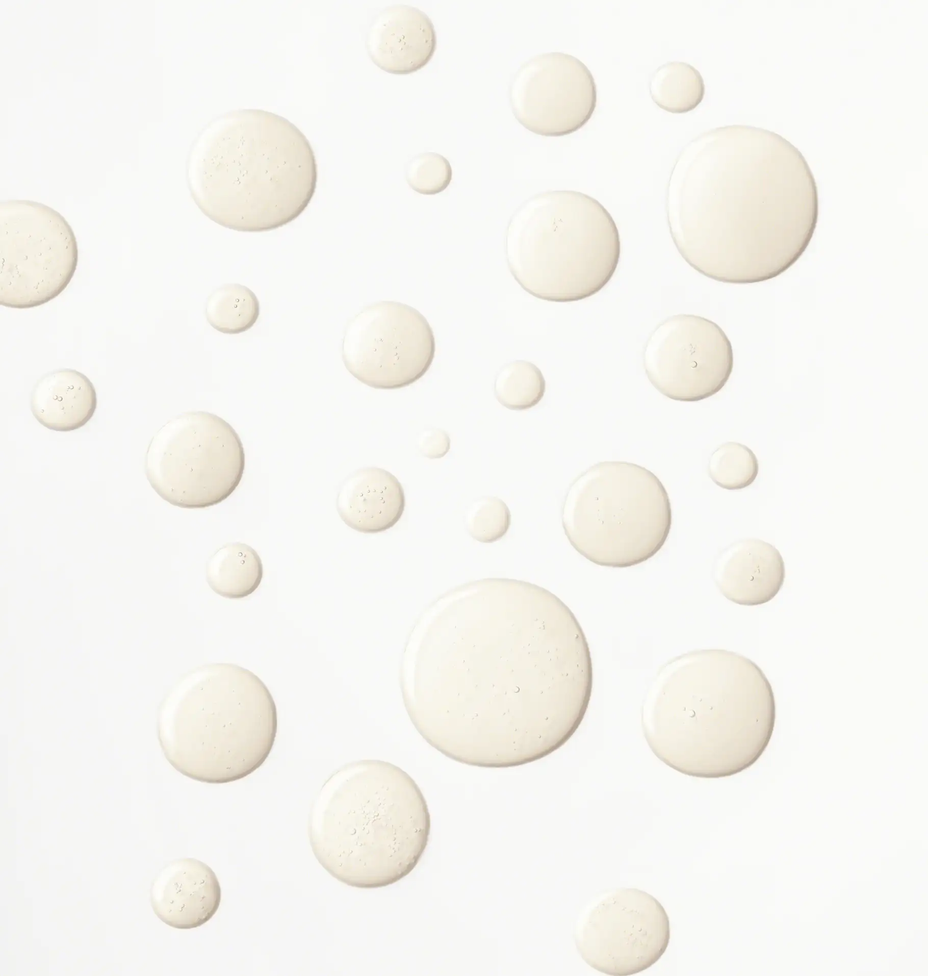 Textur von klarem, leicht schimmerndem Gesichtsgel in verschiedenen Tropfen auf weißem Hintergrund