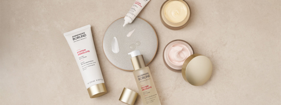 ANNEMARIE BÖRLIND SYSTEM ABSOLUTE mit Gesichtscreme, Serum und Lotion auf beigem Hintergrund