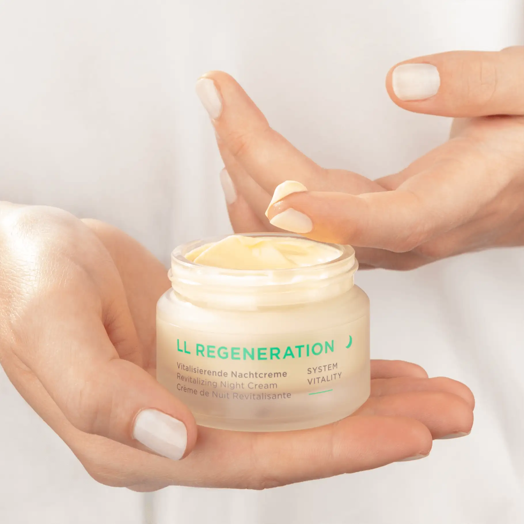 LL REGENERATION vitalisierende Nachtcreme im Tiegel, Hand hält Creme, Finger entnimmt Produkt