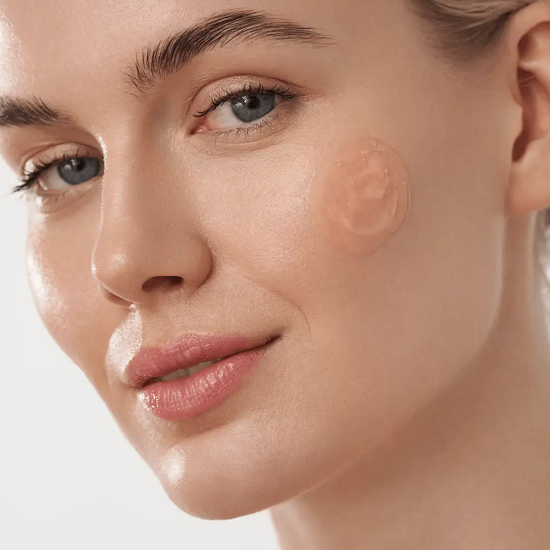 Nahaufnahme eines Gesichts mit klarem Teint und einem Klecks GEL auf der Wange zur Produktanwendung