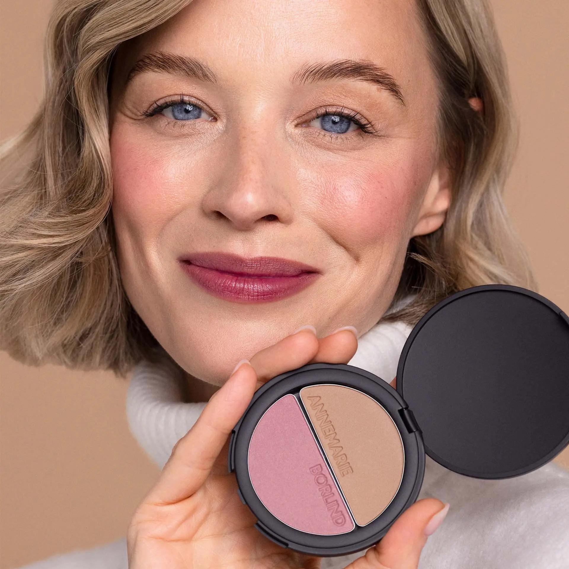 Model mit ANNEMARIE BÖRLIND Make-up Duo mit Bronzer und Rouge in schwarzer runder Dose