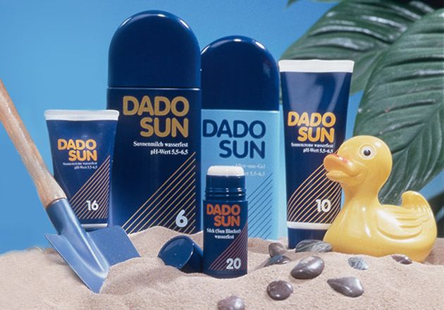 DADO SUN Sonnenmilch und Gel mit LSF 6, 10, 16, 20 in Sand mit Gummiente und kleiner Schaufel