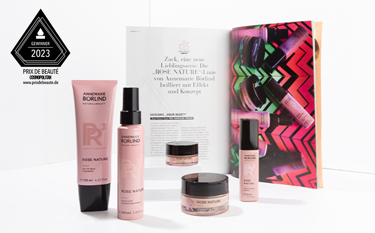 ANNEMARIE BÖRLIND ROSE NATURE Pflegeserie mit Cleanser, Spray, Creme und Serum vor Magazinseite und Prix de Beauté 2023 Ge...