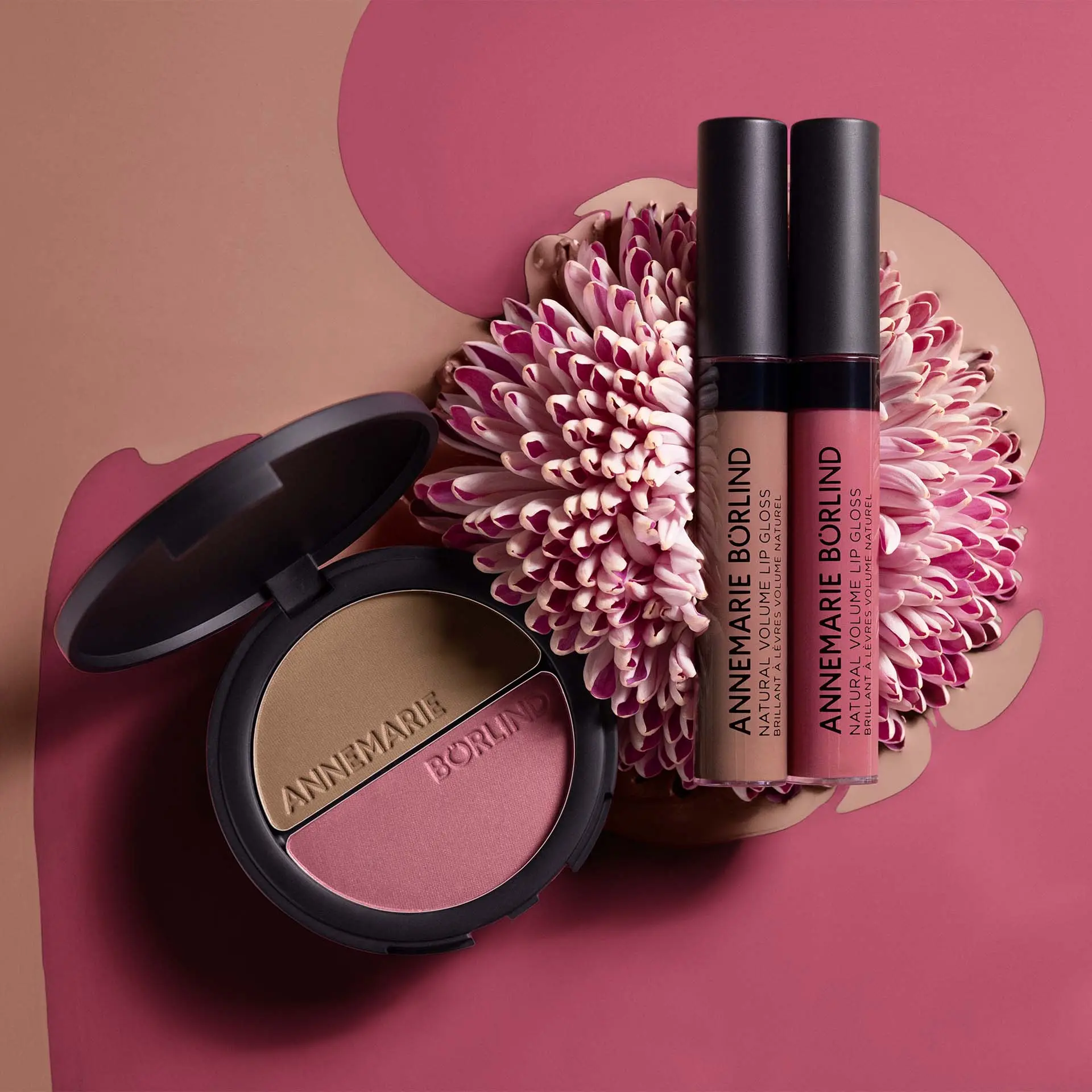 ANNEMARIE BÖRLIND Make-up Duo Bronzer & Rouge, Natural Volumen Snuggle Berry und Nude Hug auf Blume vor farbigem Hintergrund