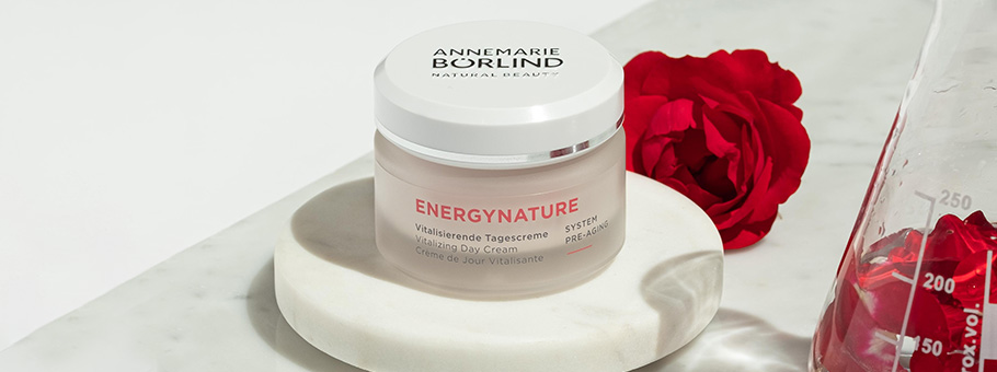 ANNEMARIE BÖRLIND ENERGYNATURE vitalisierende Tagescreme auf Marmorplatte mit roten Rosen und Messkolben