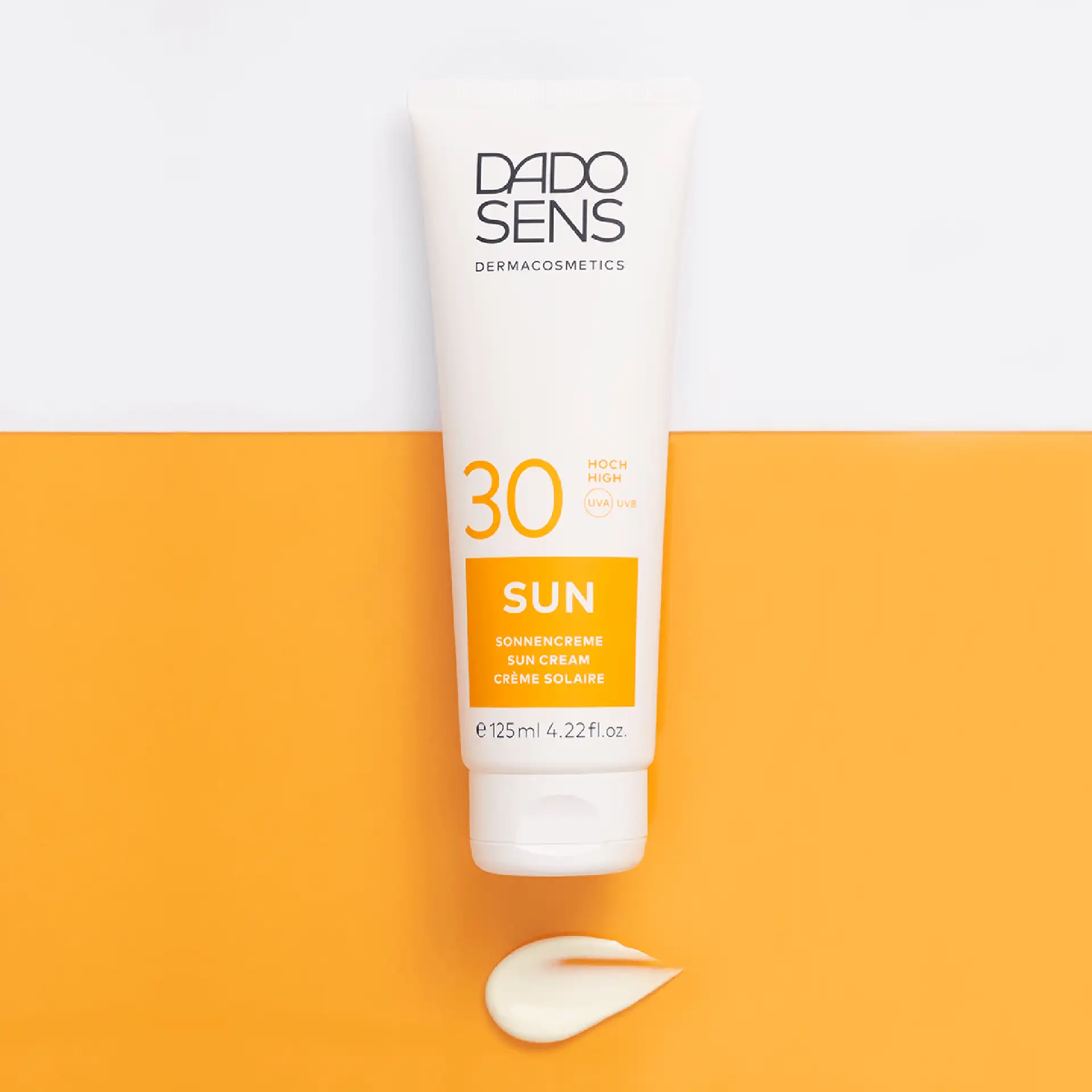 DADO SENS SUN Sonnencreme SPF 30 in 125 ml Tube mit Cremeprobe auf orange-weißem Hintergrund