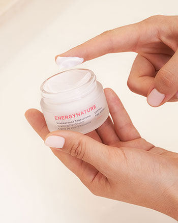 ENERGYNATURE Vitalisierende Tagescreme im geöffneten Tiegel, Creme auf Fingerspitze sichtbar