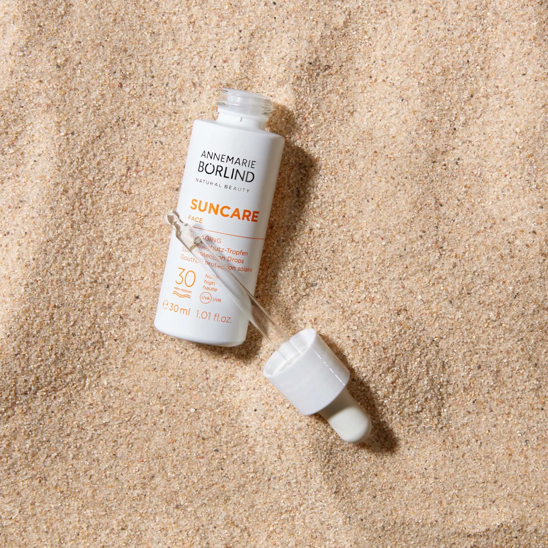 ANNEMARIE BÖRLIND Suncare Anti-Aging Sonnenschutz-Tropfen LSF 30 mit Pipette auf Sand