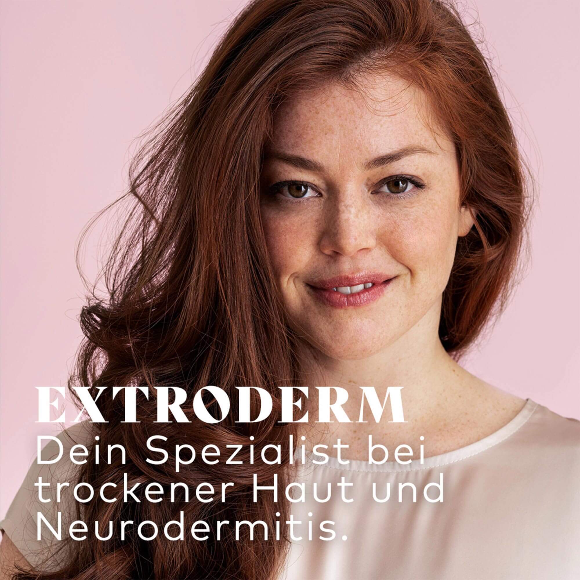 Nahaufnahme einer lächelnden Frau mit roten Haaren vor rosa Hintergrund, Text zu EXTRODERM Hautpflege