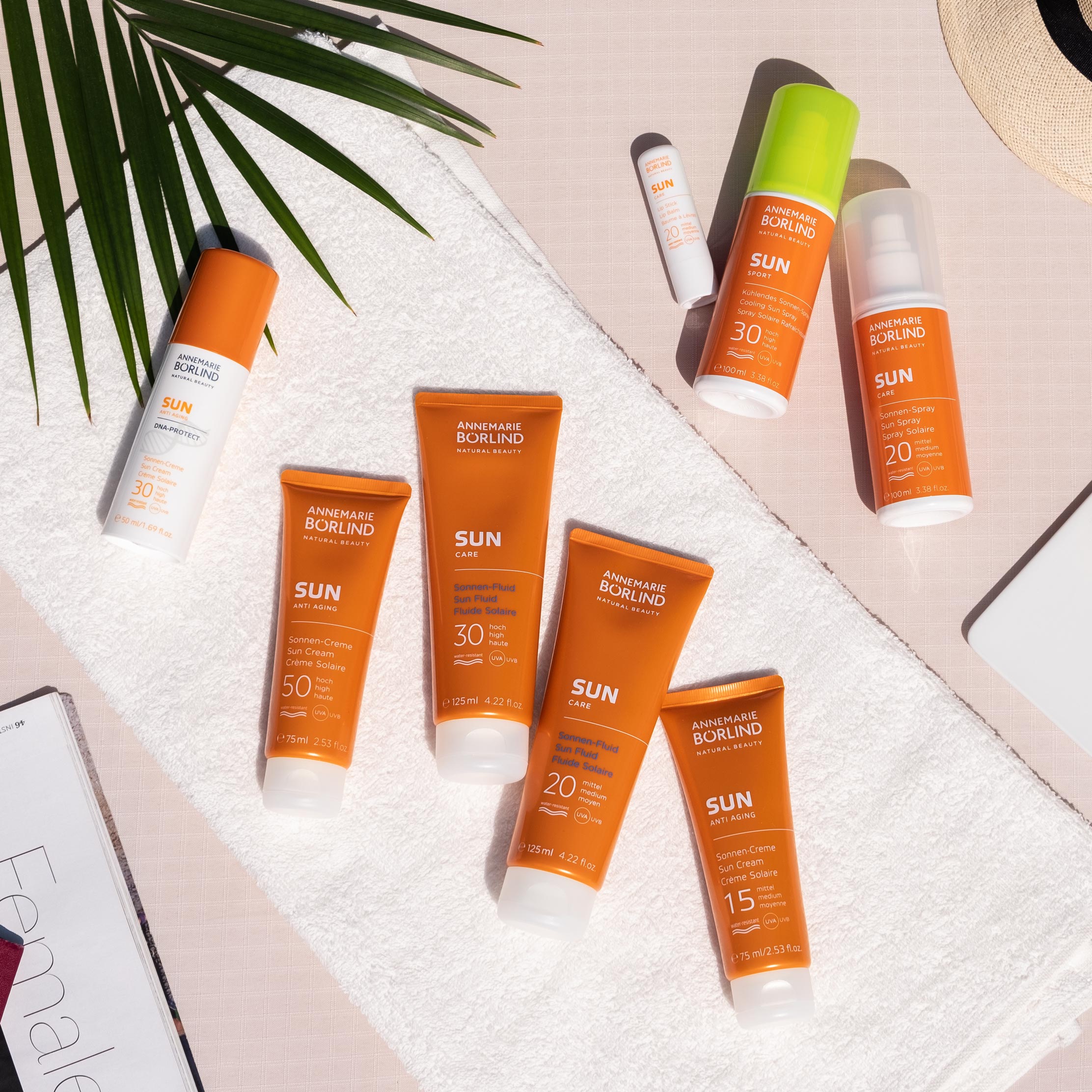 ANNEMARIE BÖRLIND SUN Sonnencremes und Sprays mit Lichtschutzfaktoren 15 bis 50 auf weißem Handtuch