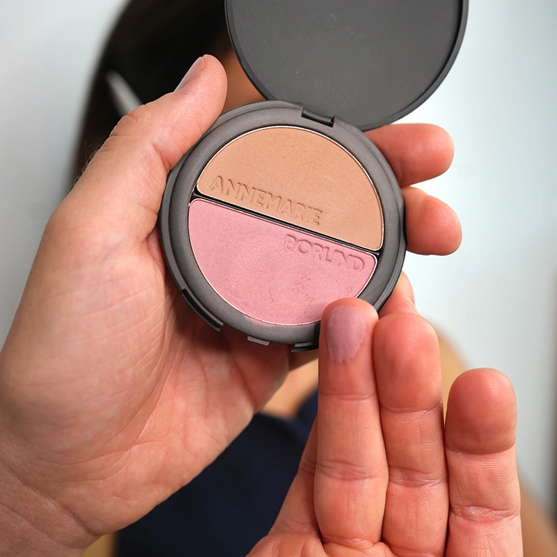 Make-up Artist Kevin Bete zeigt die Farbnuancen des ANNEMARIE BÖRLIND 2in1 Bronzer & Blush für den Herbst Make-up Look „A Hug of Colour“ auf den Fingern