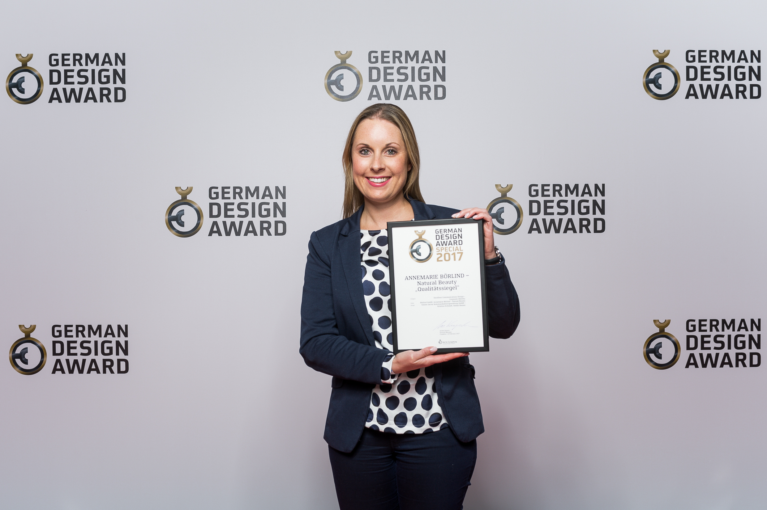 Frau hält Urkunde mit GERMAN DESIGN AWARD 2017 für ANNEMARIE BÖRLIND Natural Beauty Qualitätssiegel