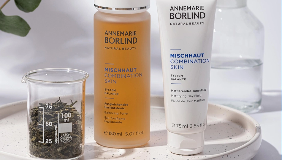 Mischhaut Pflege mit ANNEMARIE BÖRLIND: Balancing Toner und Mattifying Day Fluid der System Balance Serie, inszeniert mit grünem Tee und Wasser als Symbol für Reinheit und Ausgleich.