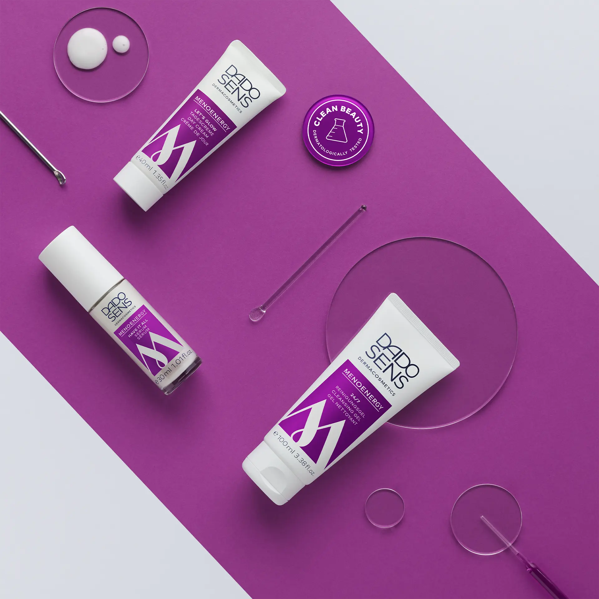 DADO SENS MENOENERGY Reinigungs-Gel, Tagescreme und Serum auf lila Hintergrund mit Proben und Pipetten