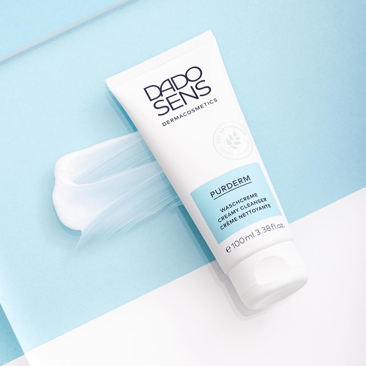 DADO SENS PURDERM Waschcreme 100 ml auf hellblauem Untergrund mit Creme-Spur