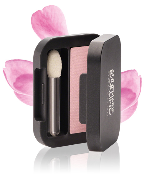 ANNEMARIE BÖRLIND Puder-Lidschatten in Rosé mit Applikator und schwarzer Klappdose vor rosa Blütenblättern