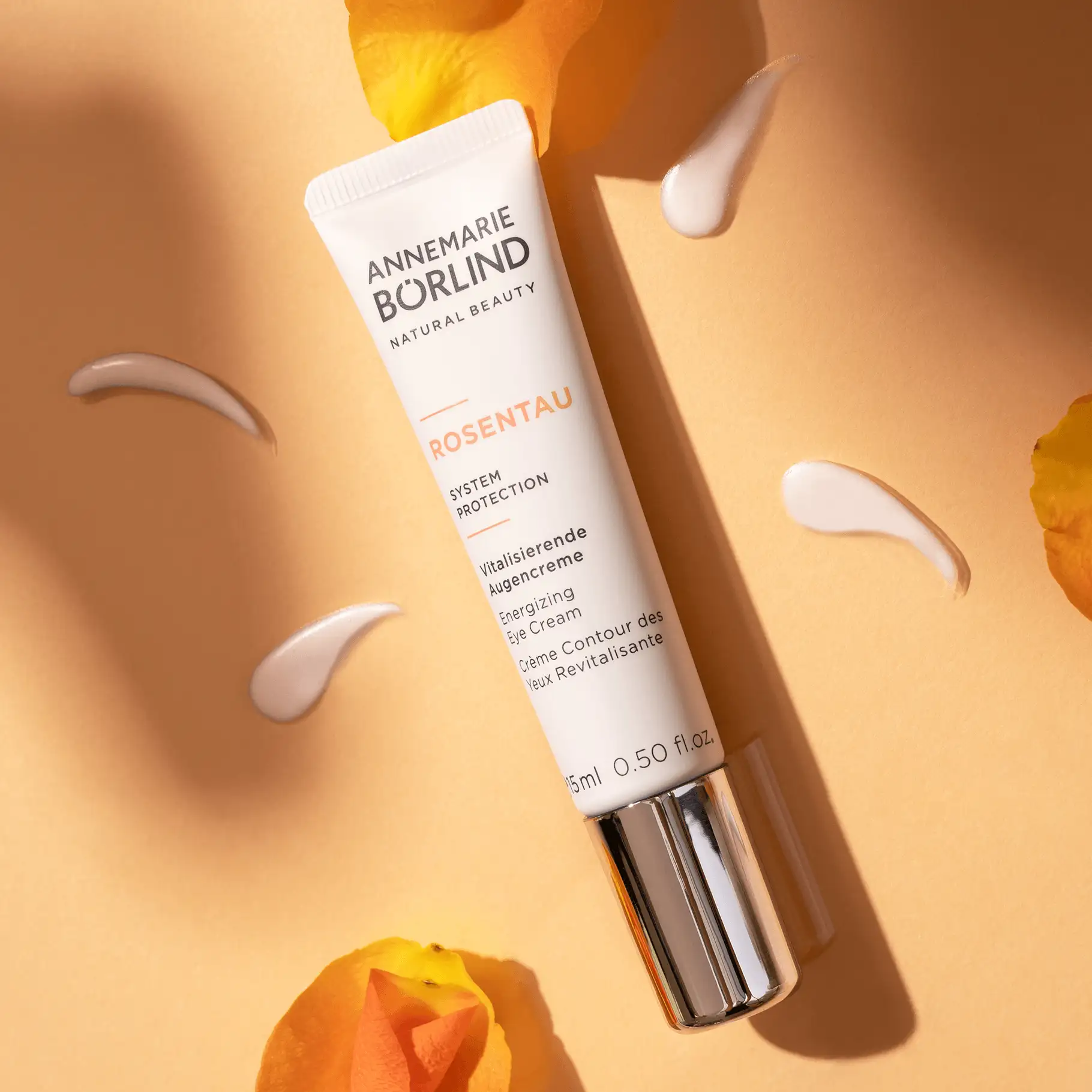 ANNEMARIE BÖRLIND ROSENTAU vitalisierende Augencreme in Tube mit Cremeproben und Rosenblüten auf beigem Hintergrund