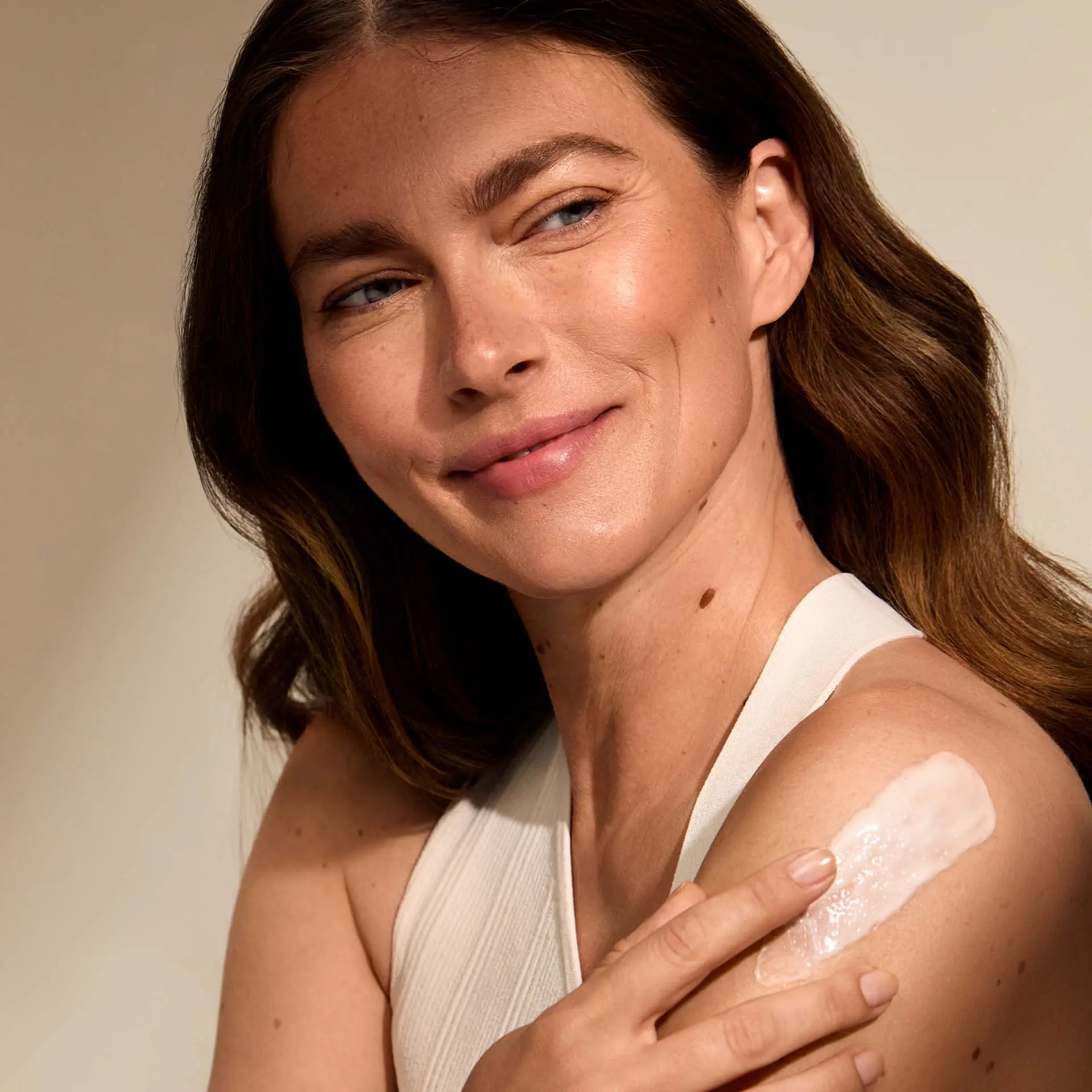 Frau trägt BODY CARE Winterwellness auf den Arm auf