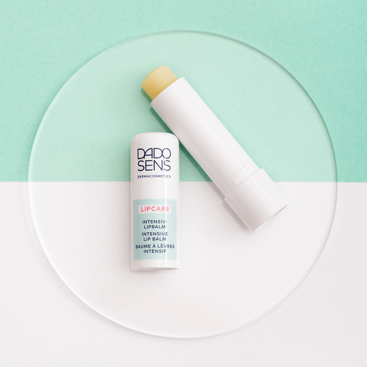 DADO SENS LIPCARE Intensiv-Lipbalm Stift mit weißem Gehäuse auf grün-weißem Hintergrund