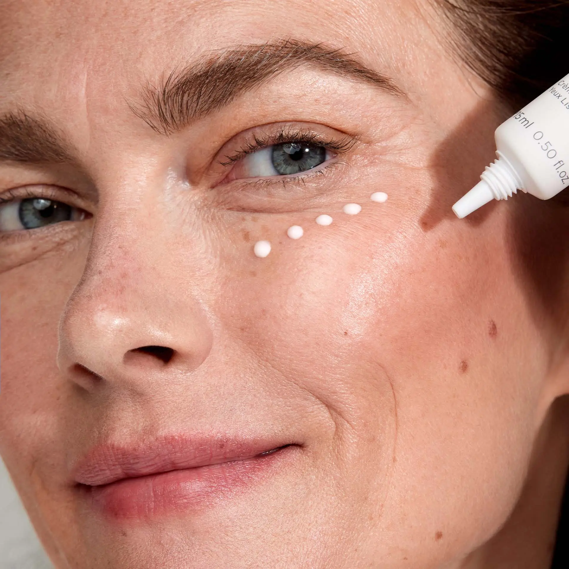 Frau wendet SYSTEM ABSOLUTE Glättende Augencreme unter den Augen an