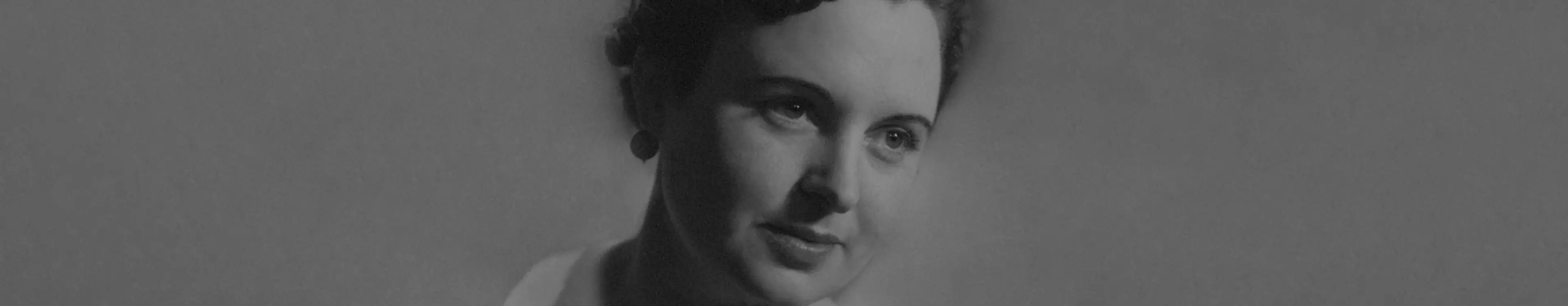 Porträt einer Frau mit zurückgebundenem Haar, die nachdenklich zur Seite blickt, schwarz-weiß.