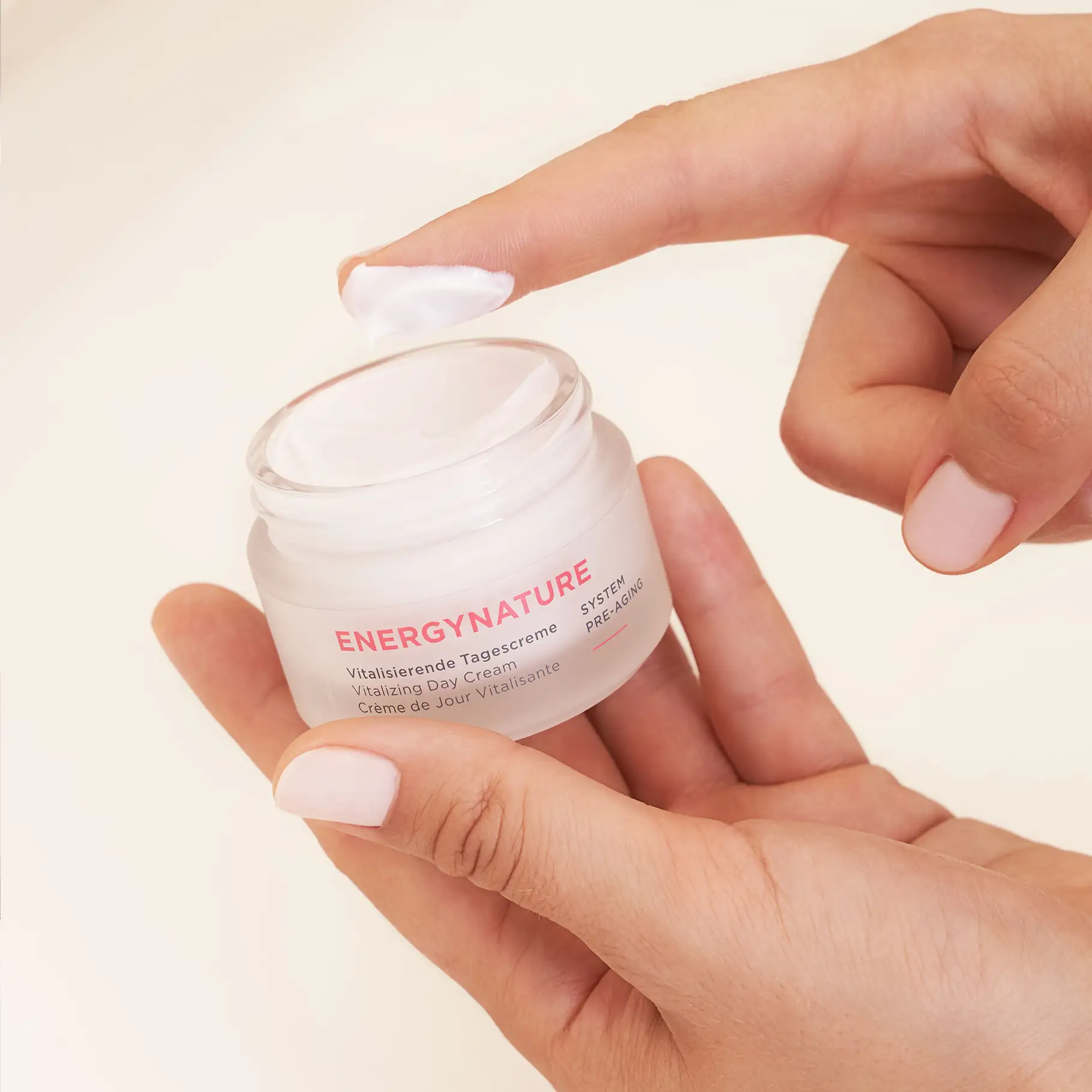 ENERGYNATURE vitalisierende Tagescreme im Tiegel, weiße Creme auf Finger, helle Haut, Nahaufnahme