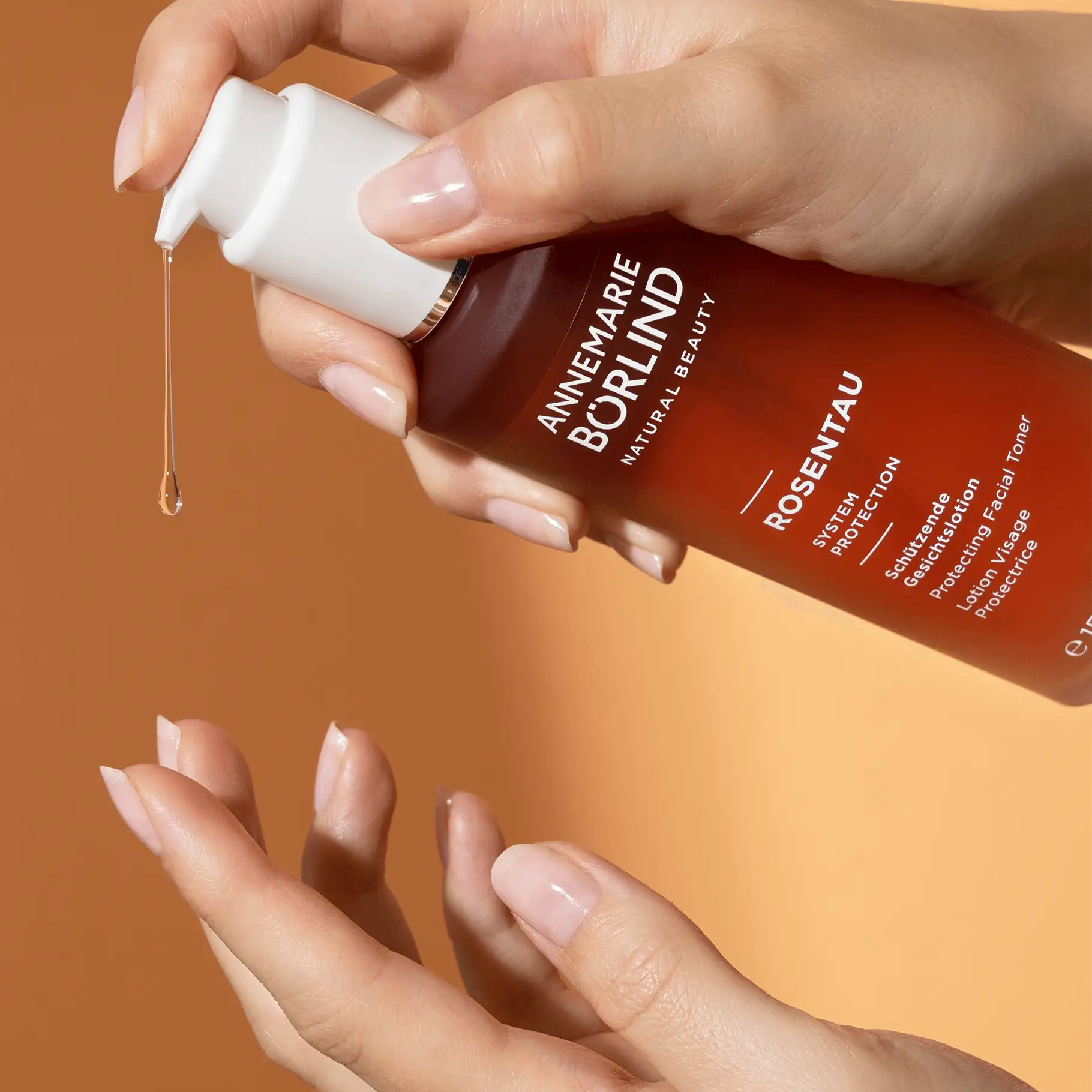 ANNEMARIE BÖRLIND Rosentau schützende Gesichtslotion mit Pumpspender, Flüssigkeit tropft auf Handfläche