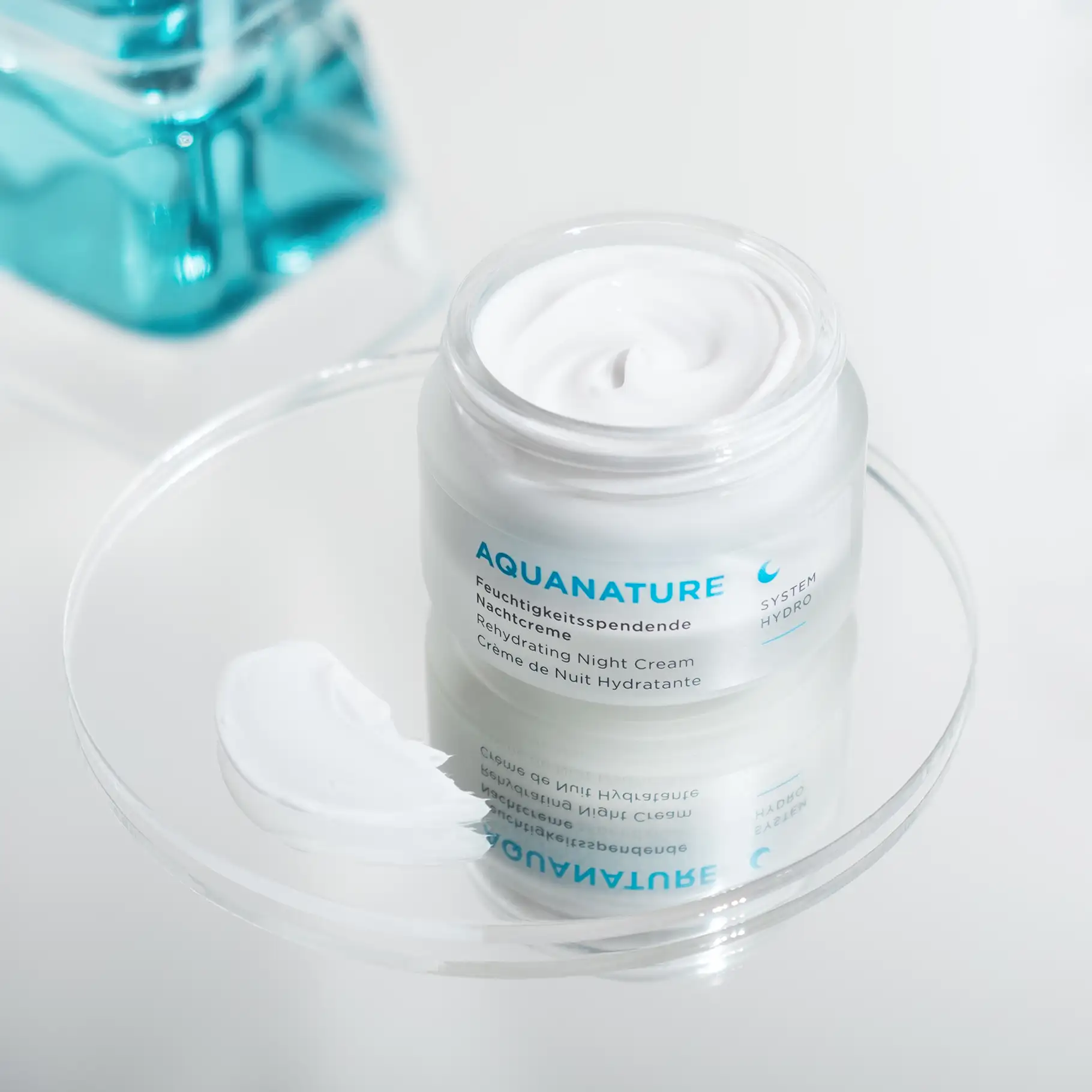 AQUANATURE feuchtigkeitsspendende Nachtcreme im geöffneten Tiegel mit Cremeprobe auf Glasplatte