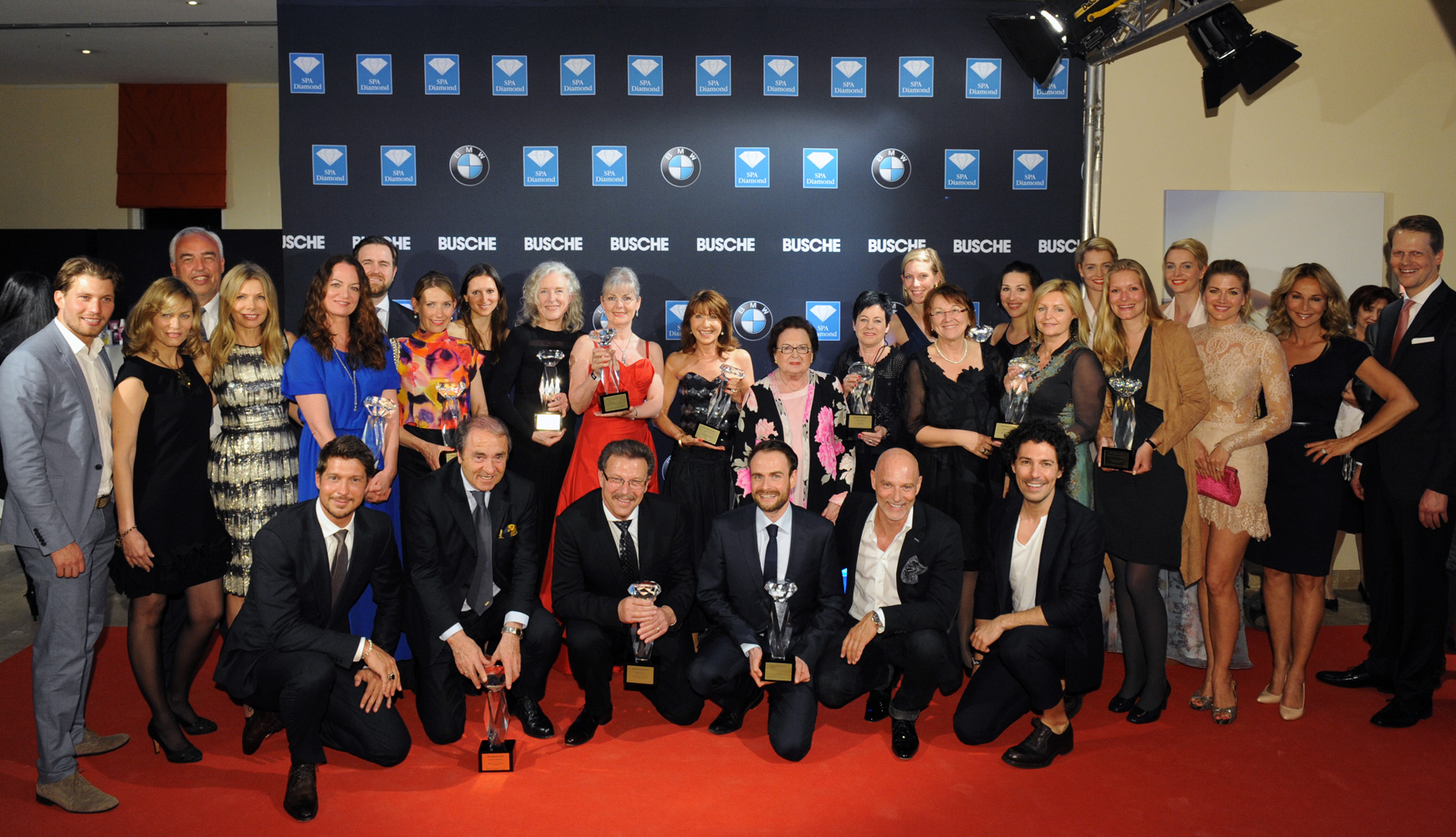 Gruppenfoto von Personen auf rotem Teppich bei SPA Diamond Award 2015 mit Pokalen vor Sponsorenwand